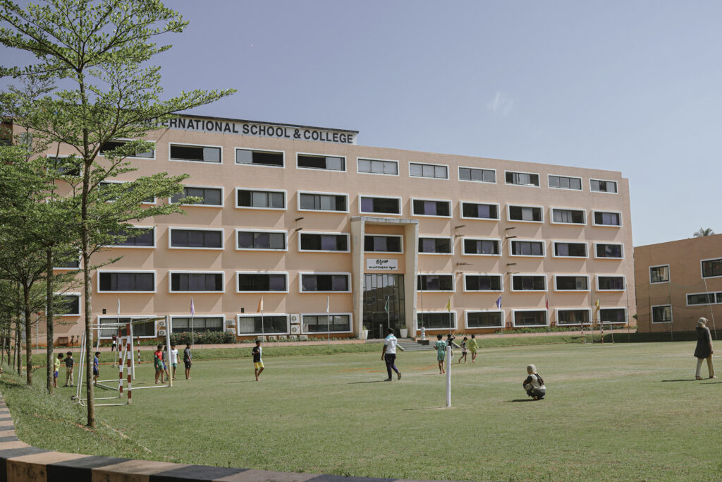 Prestige International School infrastructure featuring spacious playground and student transport facilities.