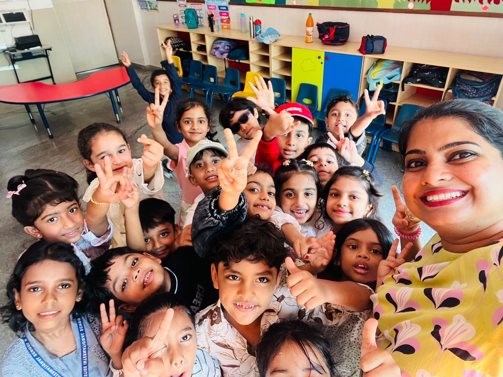 Teacher and students together, smiling in a classroom